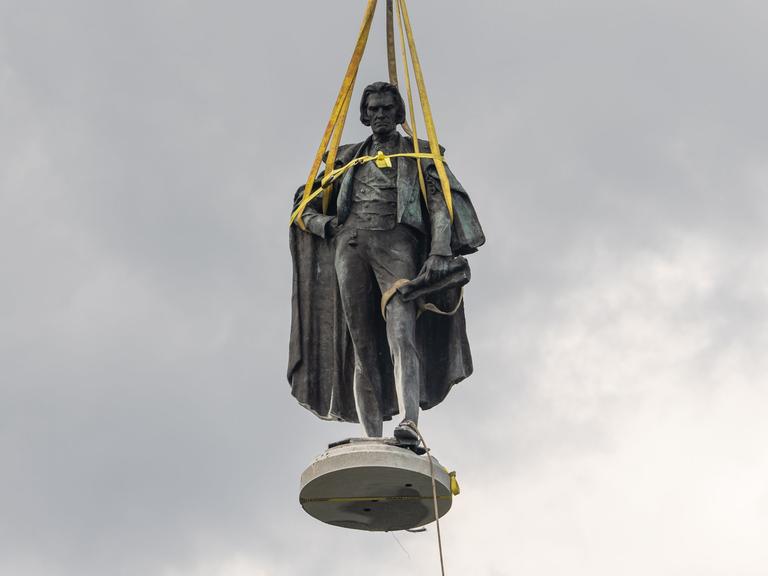 Eine Statur ist mit Bändern versehen, um sie vom Sockel zu heben. Es ist die Statur des ehemaligen Vizepräsidenten John Calhoun, der die Sklaverei befürwortet hat.