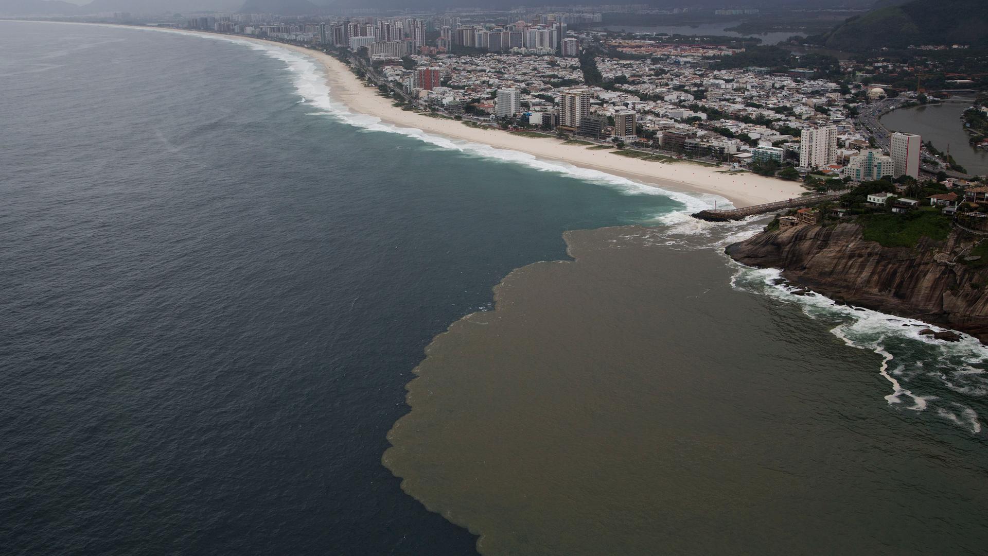 Eine Luftaufnahme von 2015 aus Brasilien zeigt verschmutztes Wasser, das vom Barra-Kanal zum Barra-Strand in Rio de Janeiro fließt. Eine Luftaufnahme von 2015 aus Brasilien zeigt verschmutztes Wasser, das vom Barra-Kanal zum Barra-Strand in Rio de Janeiro fließt.