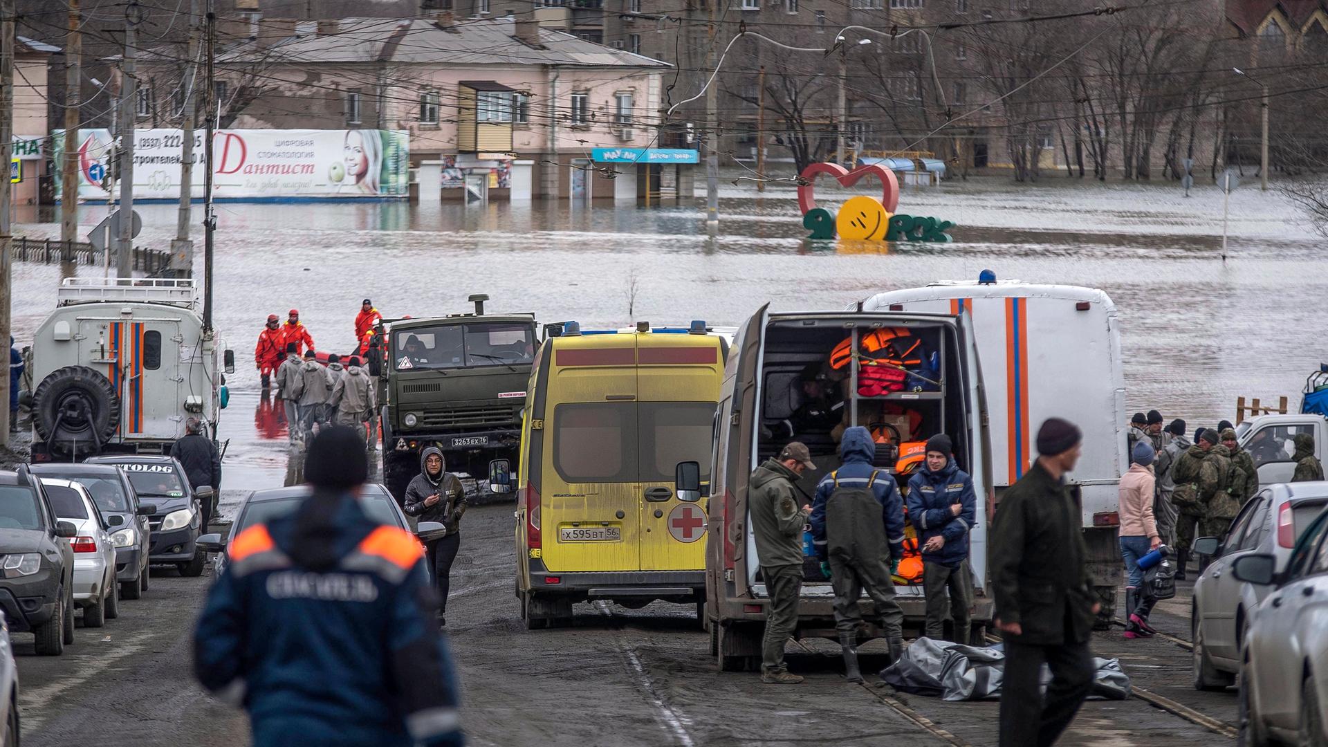 Russland, Orsk: Rettungskräfte versammeln sich in der Nähe ihrer Fahrzeuge einer überfluteten Straße, nachdem Teile eines Staudamms gebrochen sind. Russland, Orsk: Rettungskräfte versammeln sich in der Nähe ihrer Fahrzeuge einer überfluteten Straße, nachdem Teile eines Staudamms gebrochen sind.