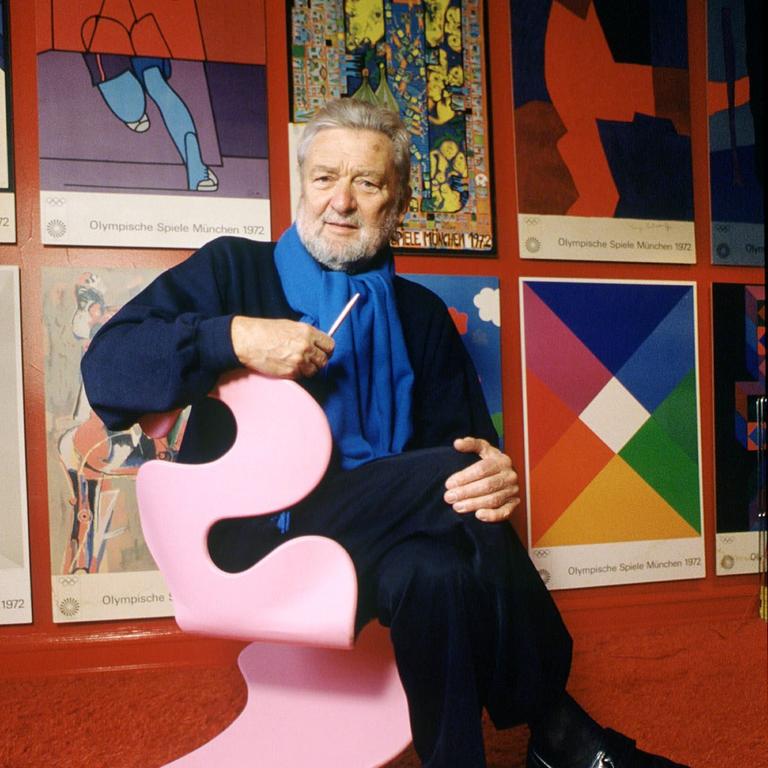 Der 1998 verstorbene Designer Verner Panton sitzt 1992 auf einem geschwungenen rosa Plastikstuhl