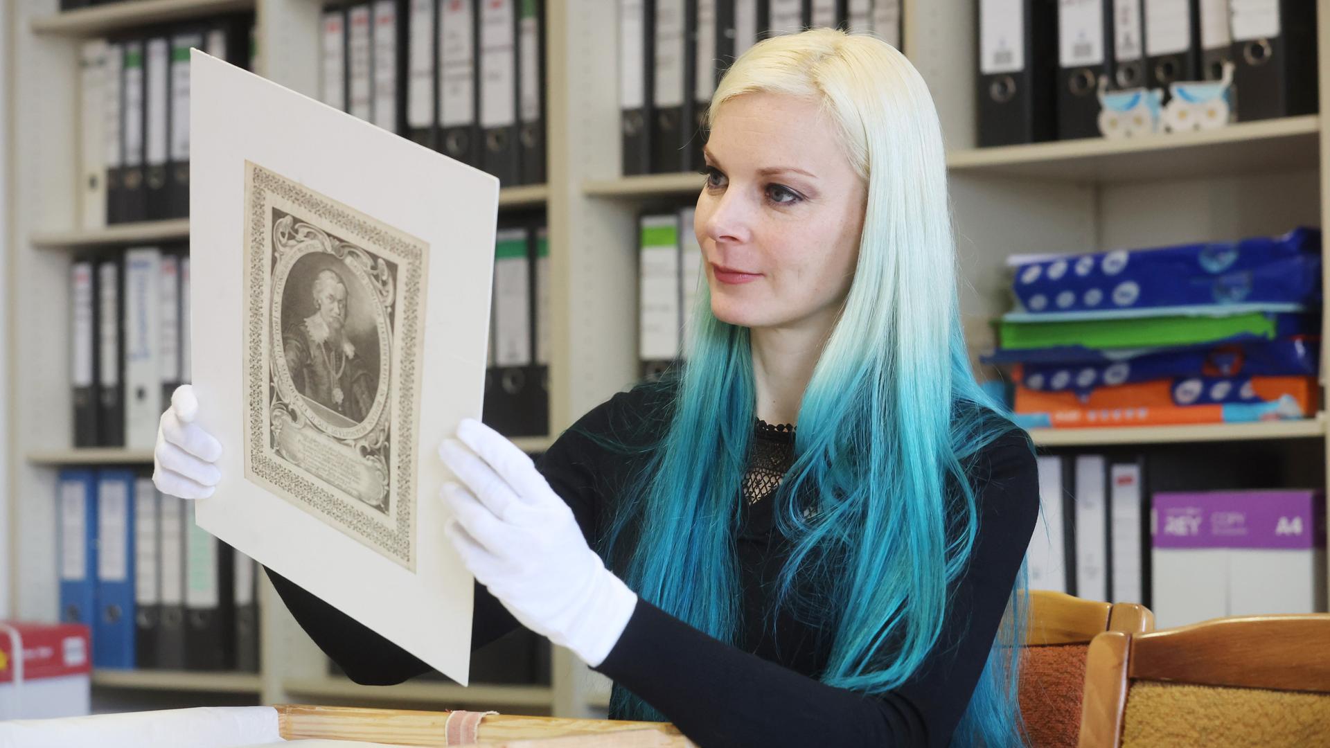 Die Provenienzforscherin Anne Paschen untersucht eine alte Zeichnung im Museum Schloss Moritzburg. Die Provenienzforscherin Anne Paschen untersucht eine alte Zeichnung im Museum Schloss Moritzburg.