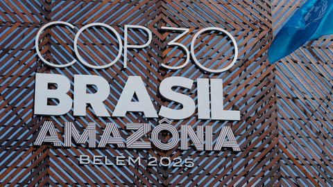 Eine Fahne der Vereinten Nationen weht neben dem Logo der Weltklimakonferenz COP30. 