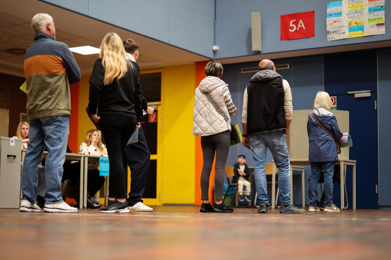 In einem Wahllokal in Duisburg-Neumühl stehen Menschen und warten auf eine freie Wahlkabine In einem Wahllokal in Duisburg-Neumühl stehen Menschen und warten auf eine freie Wahlkabine