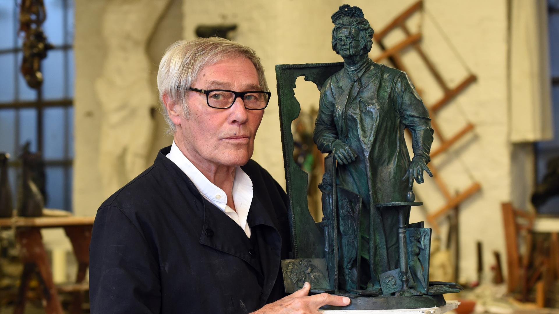 Der Bildhauer Bert Gerresheim steht in seinem Atelier neben seiner Bronzestatue "Mutter Ey".