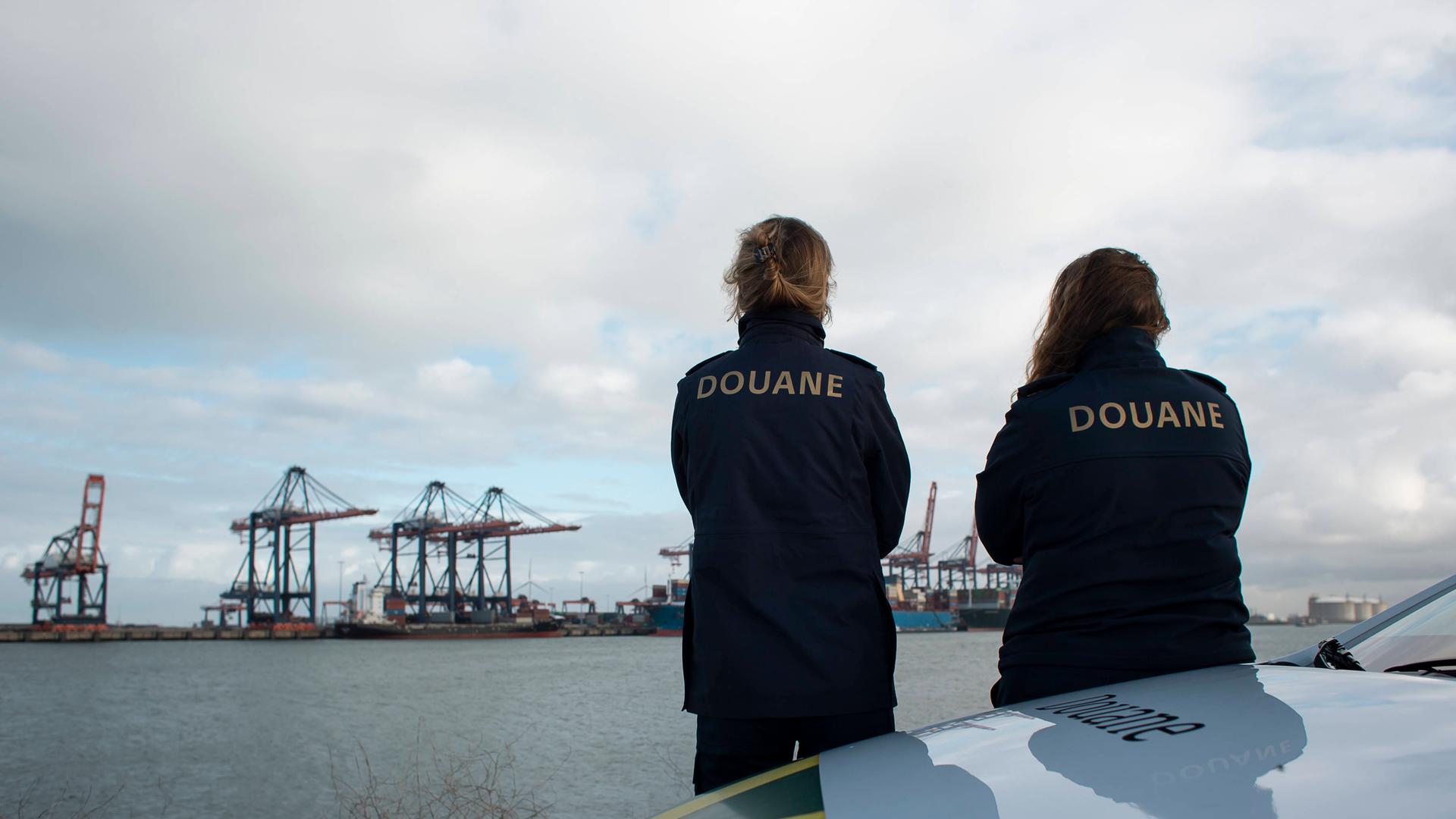 Mitarbeiterinnen des Zolls von Rotterdam schauen auf die Frachtcontainer.