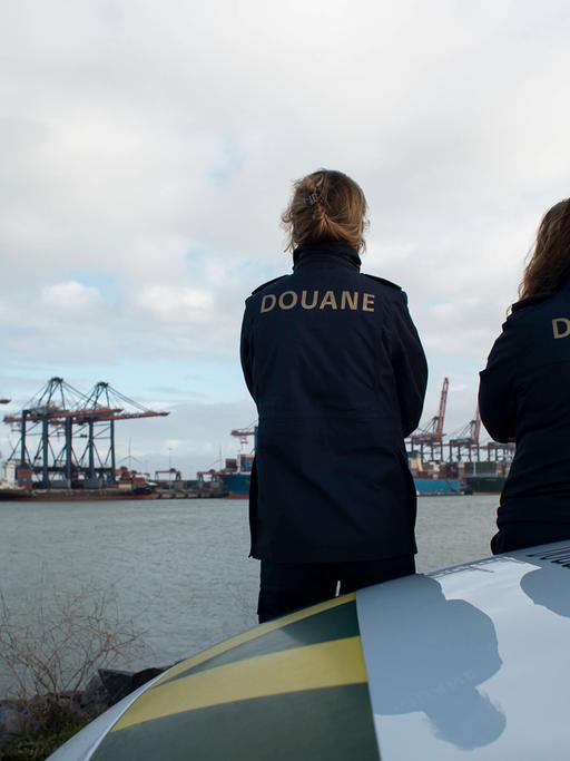 Mitarbeiterinnen des Zolls von Rotterdam schauen auf die Frachtcontainer