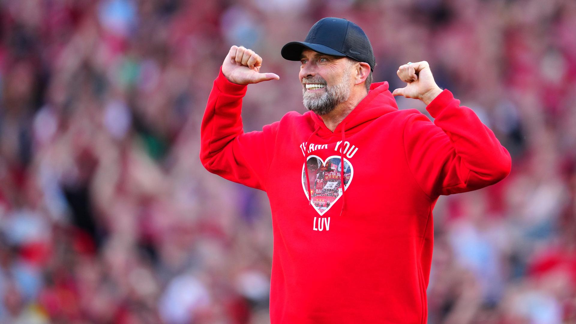 Trainer Klopp steht vor den Fans und zeigt auf die Aufschrift seines Pullovers. Darauf steht: "I´ll never walk alone"