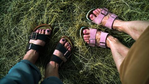 Zwei Frauen tragen Sandalen der Schuhmarke Birkenstock.