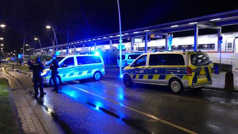 Vor einem kleinen Regionalbahnhof stehen bei Nacht Einsatzfahrzeuge der Polizei mit aktivem Blaulicht, drumhereum stehen mehrere Polizisten. Im Hintergrund ist ein auf dem Gleis stehender ICE-Zug zu sehen.