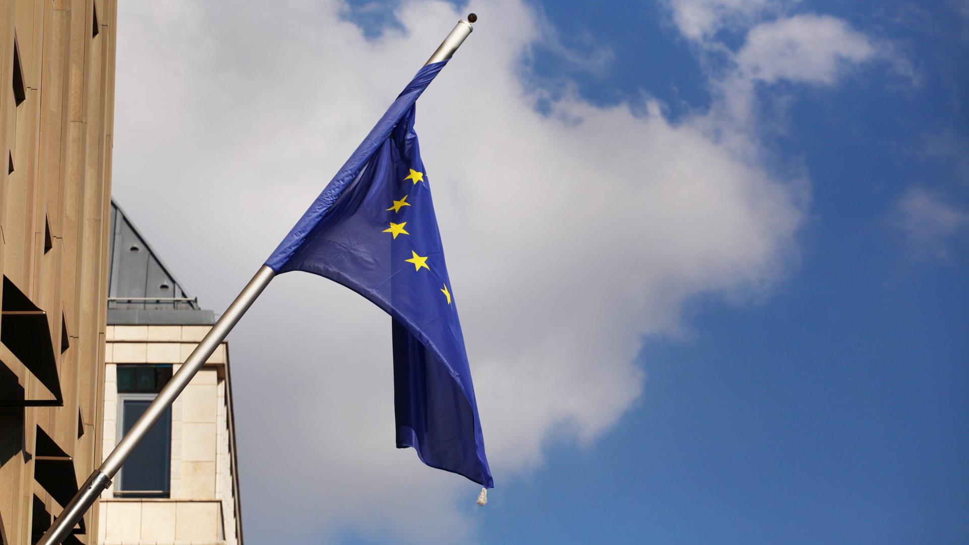 Schlapp und verdreht hängt eine Europafahne am 1an einen Gebäude. Schlapp und verdreht hängt eine Europafahne am 1an einen Gebäude.