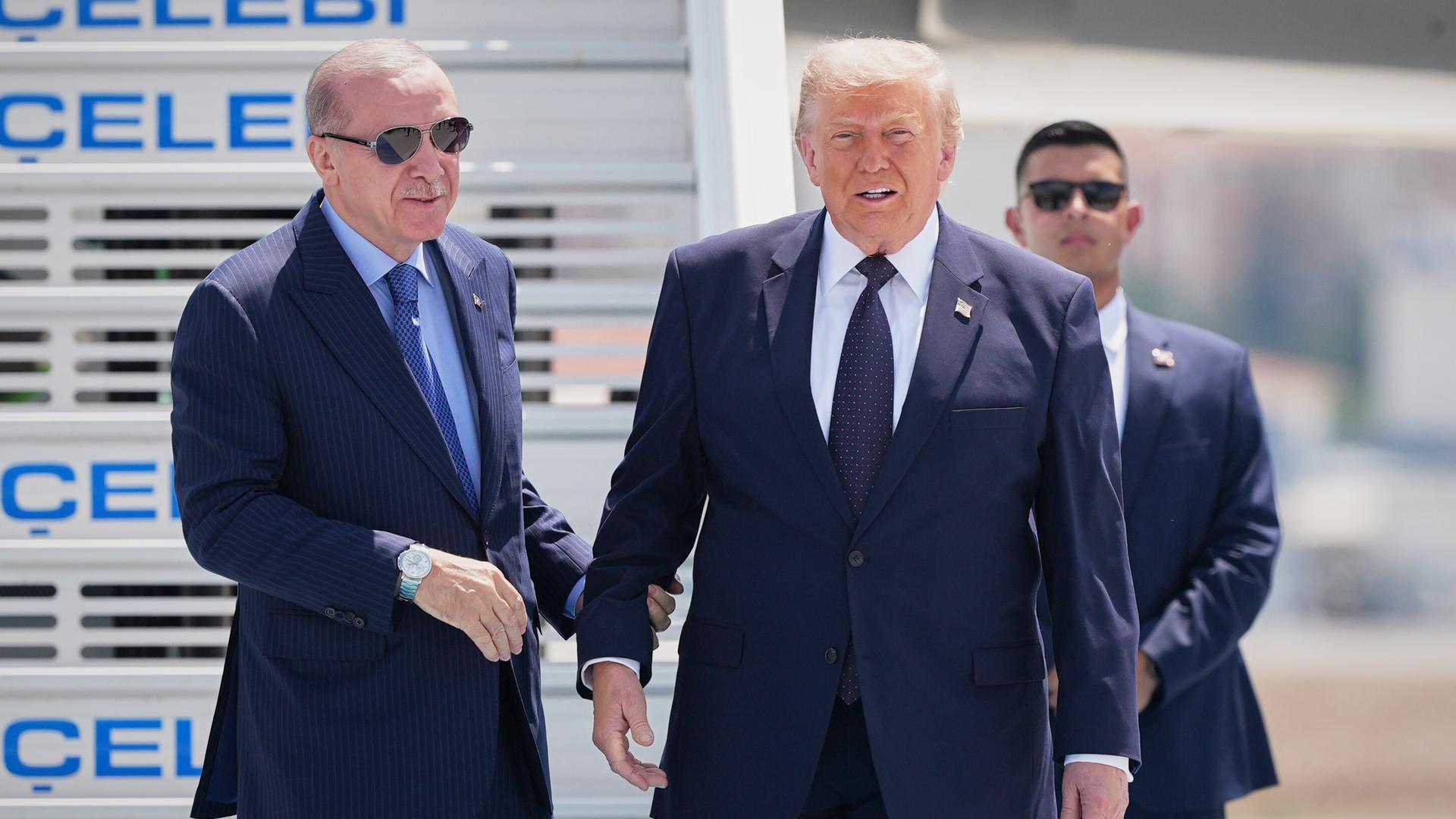Präsident Donald Trump wird bei seiner Ankunft zum NATO-Gipfel in Ankara, Türkei, vom türkischen Präsidenten Recep Tayyip Erdogan (links) begrüßt.