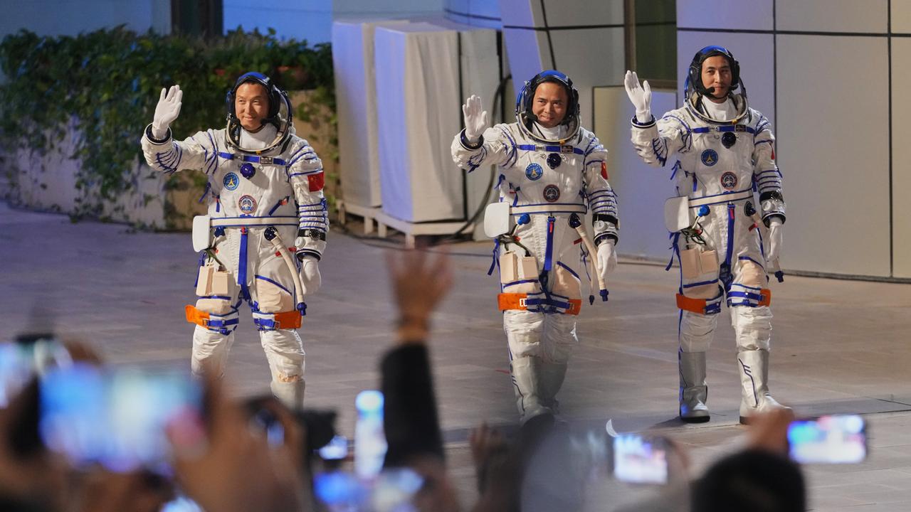 Die chinesischen Astronauten der Mission Shenzhou 21 Zhang Hongzhang (l-r), Zhang Lu und Wu Fei, winken bei der Abschiedszeremonie für ihre bemannte Raumfahrtmission im Jiuquan Satellite Launch Center.