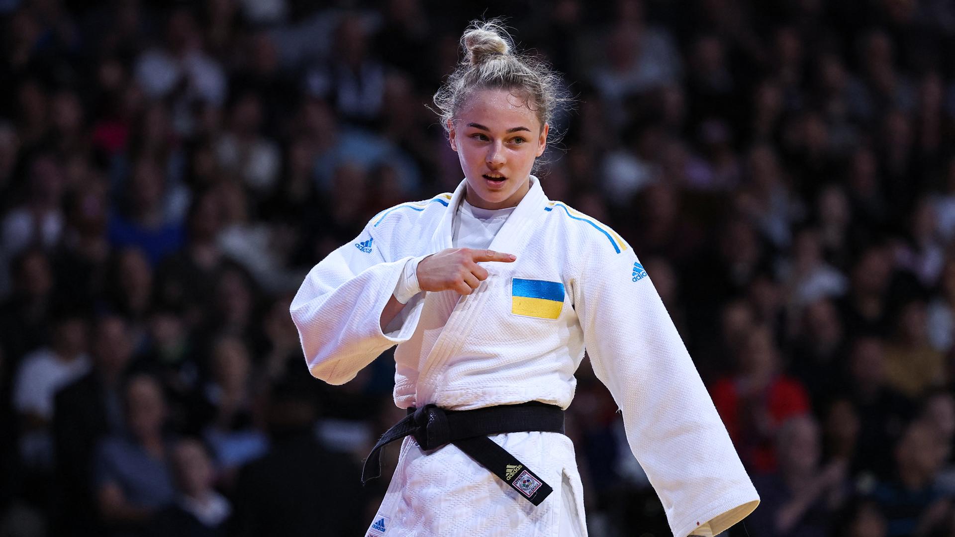 Bilodid trägt einen weißen Judoanzug mit der ukrainischen Flagge auf der linken Brustseite. Sie trägt einen schwarzen Judogürtel. Bilodid trägt einen weißen Judoanzug mit der ukrainischen Flagge auf der linken Brustseite. Sie trägt einen schwarzen Judogürtel.