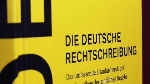 Nahaufnahme des Covers der 28. Auflage des Dudens. Schwarze Schrift auf gelben Grund.