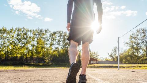 Person joggt in Sportkleidung über einen Sportplatz (Symbolbild) Person joggt in Sportkleidung über einen Sportplatz (Symbolbild)