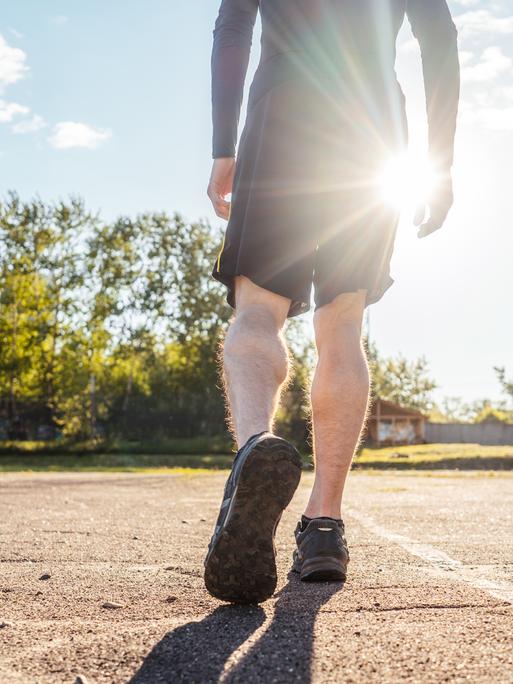 Person joggt in Sportkleidung über einen Sportplatz (Symbolbild) Person joggt in Sportkleidung über einen Sportplatz (Symbolbild)