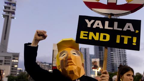 Ein Demonstrant trägt ein Kostüm von US-Präsident Donald Trump während eines Marsches in Tel Aviv und hält ein Schild mit der Aufschrift "Yalla - End it!" Ein Demonstrant trägt ein Kostüm von US-Präsident Donald Trump während eines Marsches in Tel Aviv und hält ein Schild mit der Aufschrift "Yalla - End it!"
