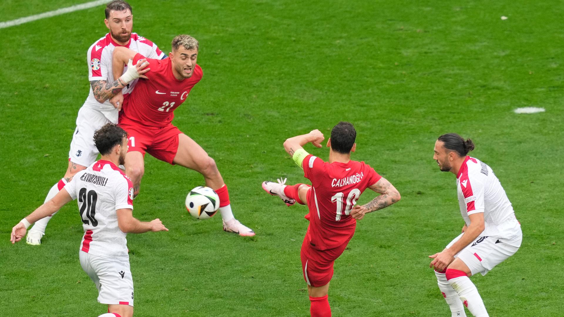 Zwei türkische und drei georgische Spieler kämpfen auf grünem Rasen um den Ball.