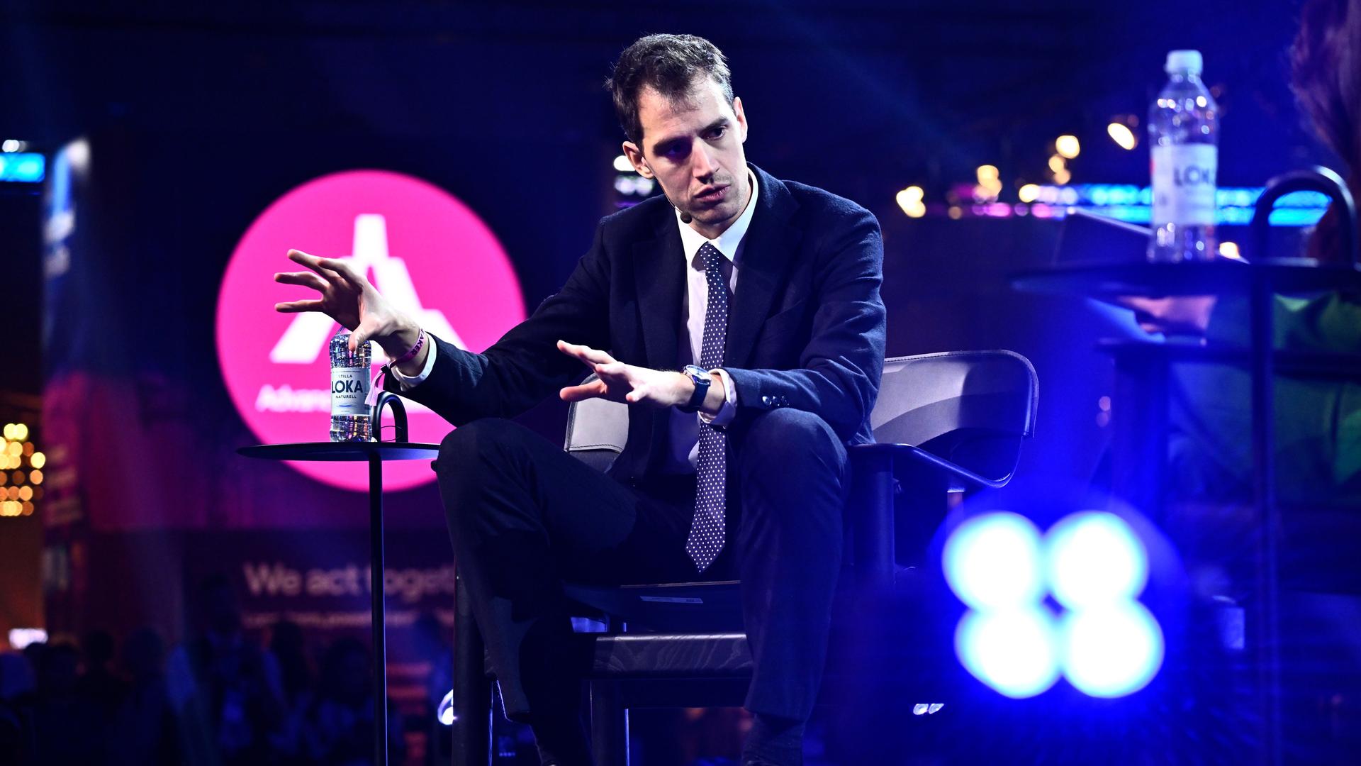 Der Mitgründer des französischen KI-Unternehmens Mistral AI, Arthur Mensch, sitzt bei einem Interview und gestikuliert mit beiden Händen.