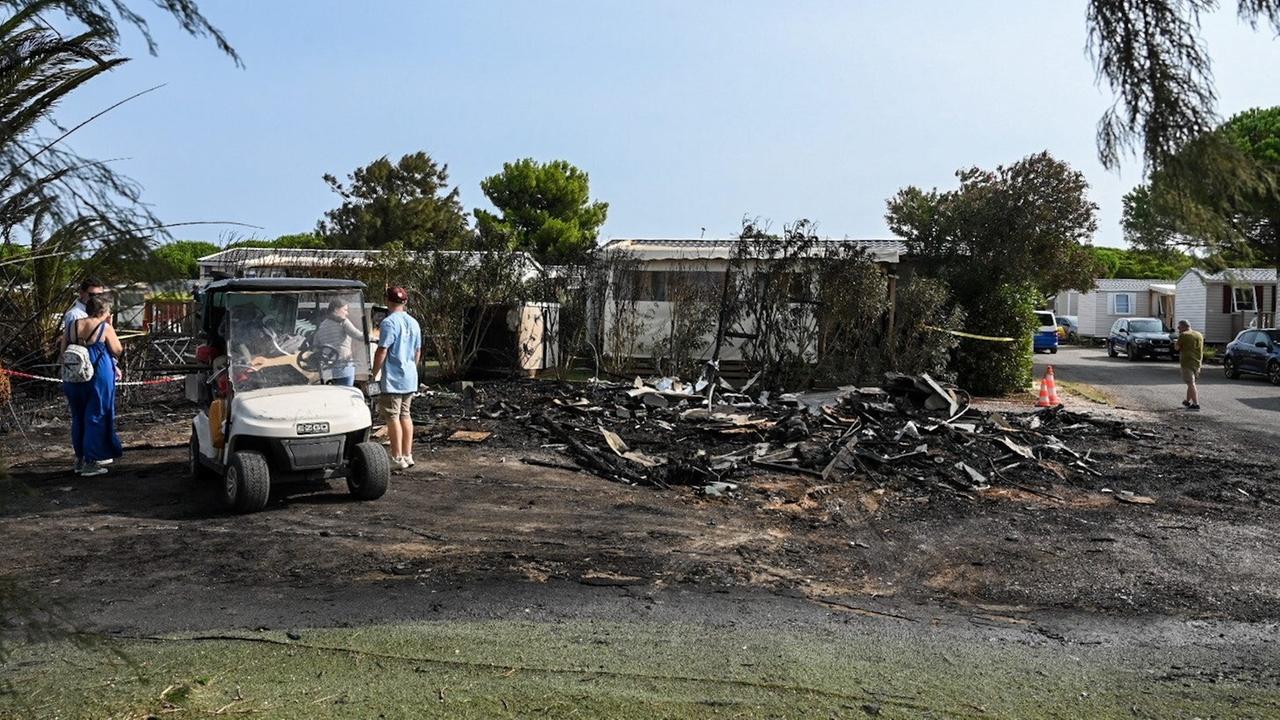 Menschen schauen sich die Zerstörung durch einen Waldbrand auf einem Campingplatz im französischen Canet-en-Roussillon an. 