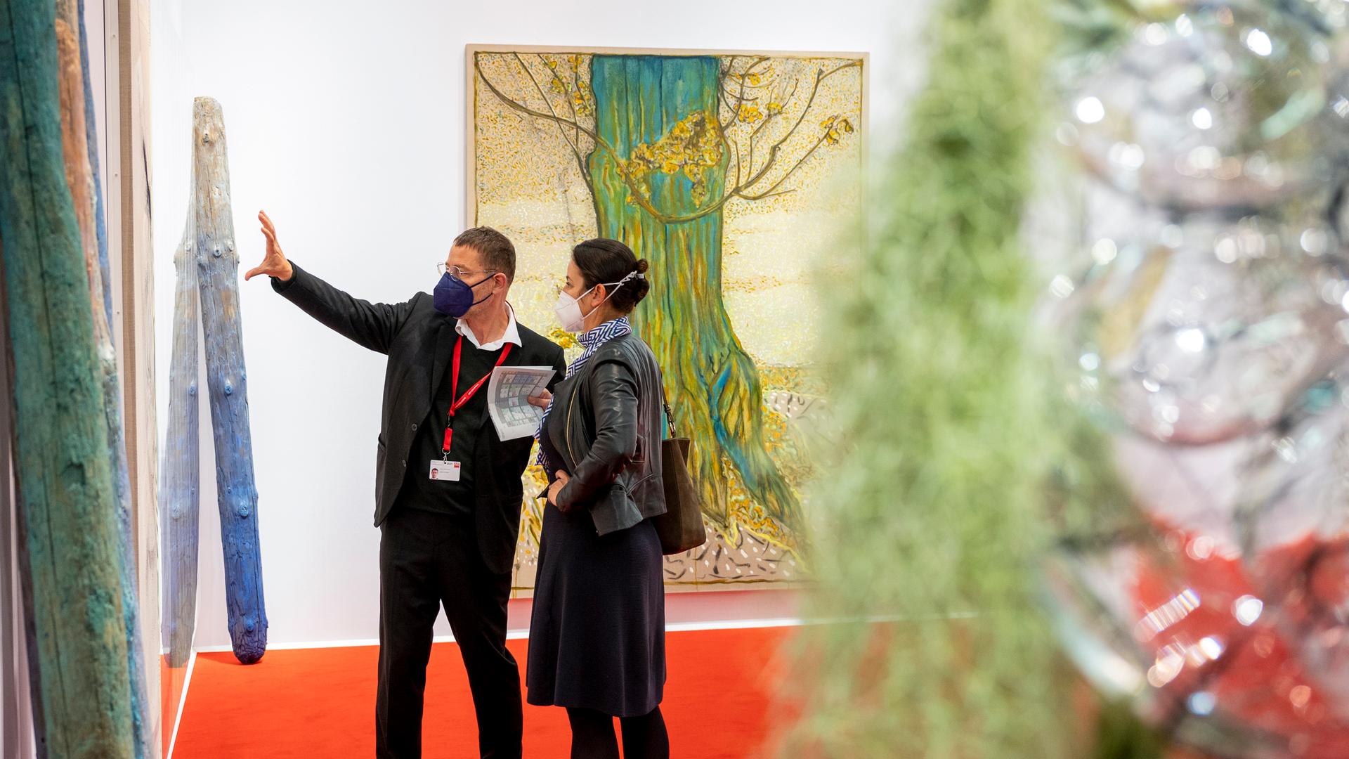 Zwei Personen betrachten ein Kunstwerk auf der Art Cologne. Zwei Personen betrachten ein Kunstwerk auf der Art Cologne.