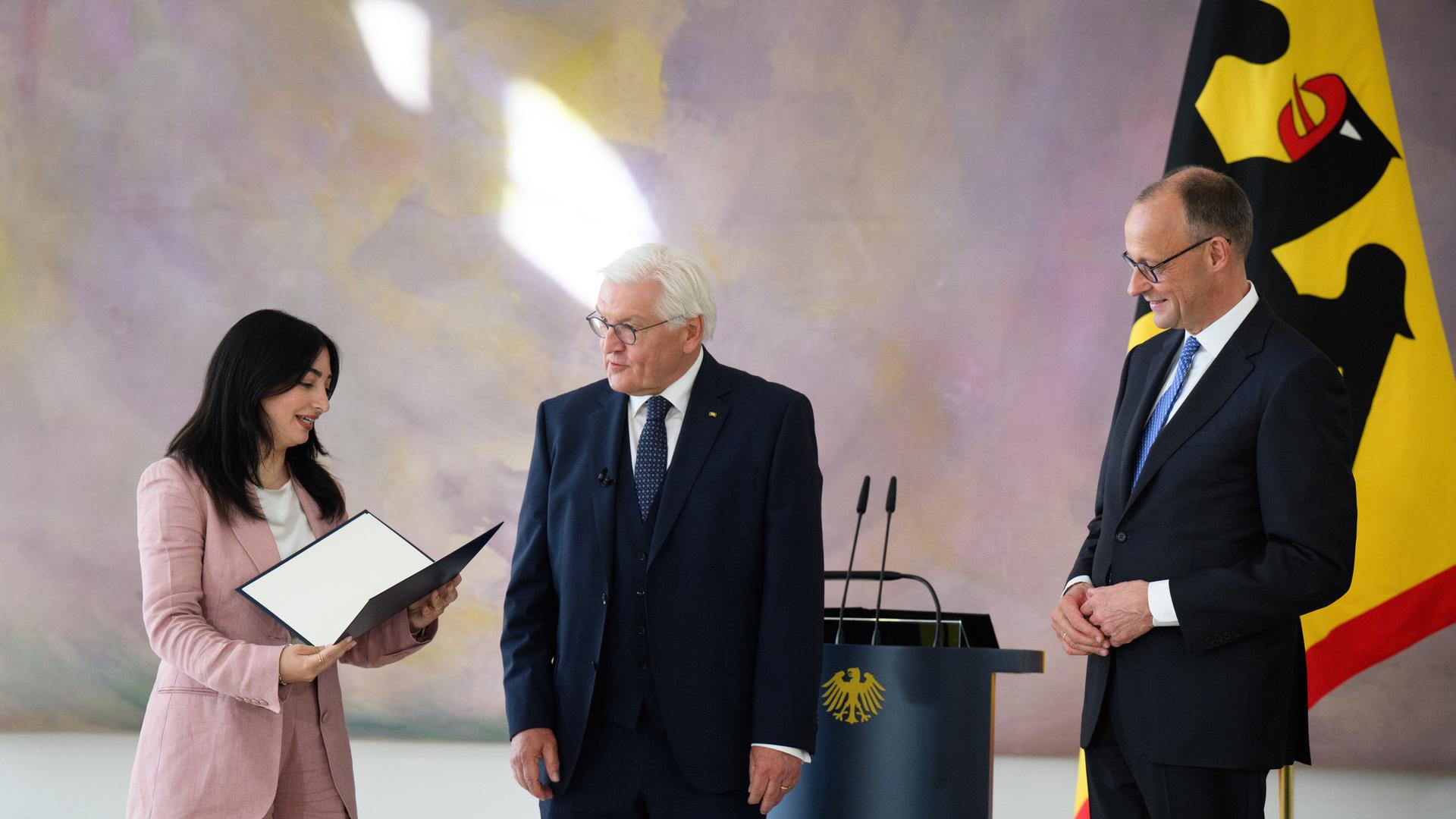 Bundespräsident Frank-Walter Steinmeier (M) übergibt Reem Alabali-Radovan (SPD), Bundesministerin für Wirtschaftliche Zusammenarbeit und Entwicklung, in Anwesenheit von Bundeskanzler Friedrich Merz (r, CDU), im Schloss Bellevue die Ernennungsurkunde. Bundespräsident Frank-Walter Steinmeier (M) übergibt Reem Alabali-Radovan (SPD), Bundesministerin für Wirtschaftliche Zusammenarbeit und Entwicklung, in Anwesenheit von Bundeskanzler Friedrich Merz (r, CDU), im Schloss Bellevue die Ernennungsurkunde.