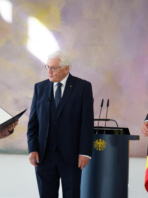 Bundespräsident Frank-Walter Steinmeier (M) übergibt Reem Alabali-Radovan (SPD), Bundesministerin für Wirtschaftliche Zusammenarbeit und Entwicklung, in Anwesenheit von Bundeskanzler Friedrich Merz (r, CDU), im Schloss Bellevue die Ernennungsurkunde.
