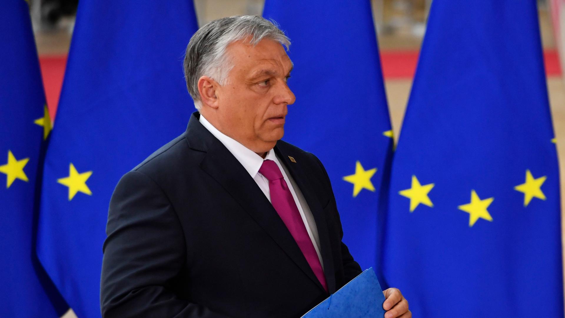 Belgien, Brüssel: Viktor Orban, Premierminister von Ungarn, läuft an EU-Fahnen entlang.