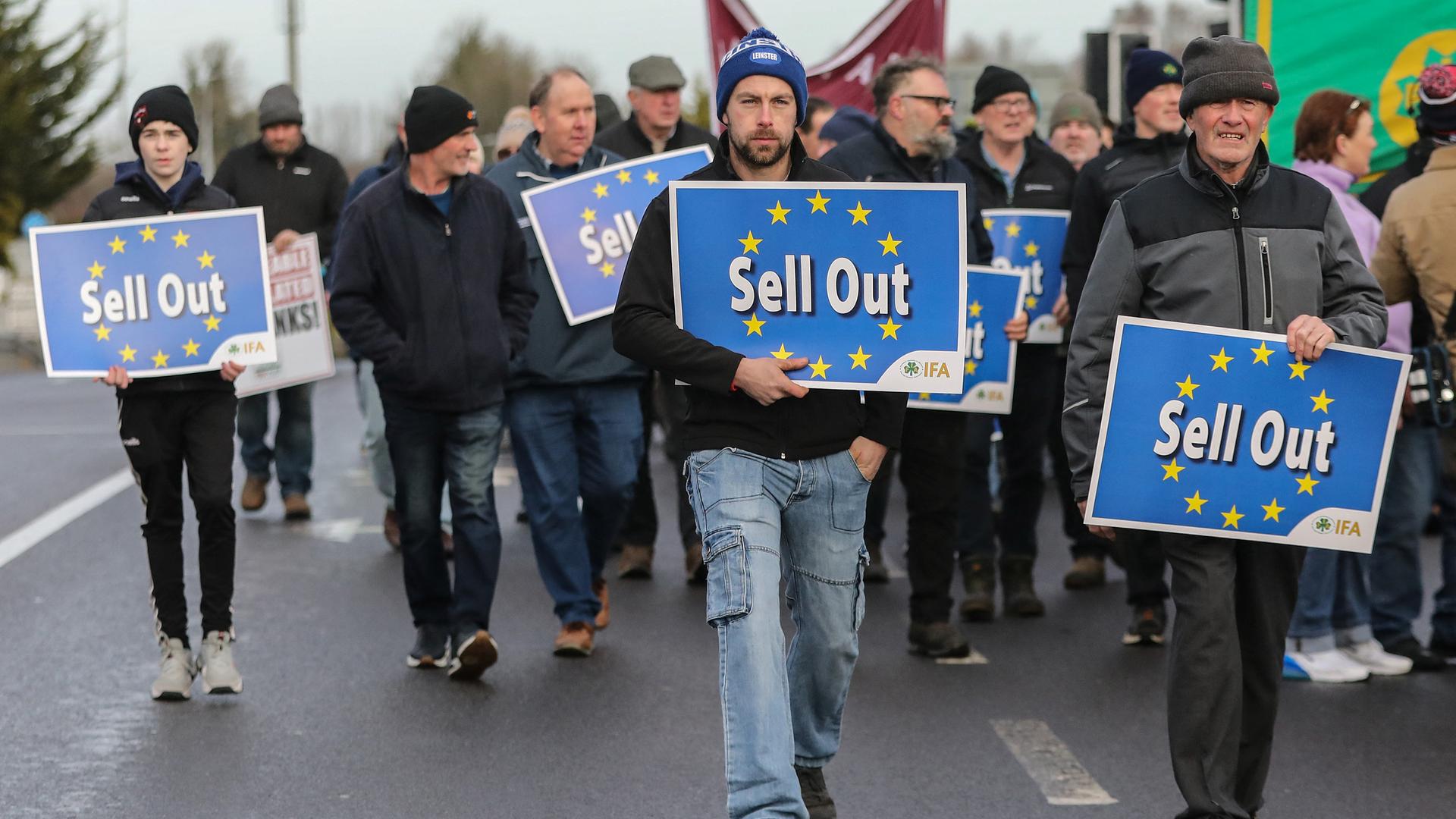 Demonstranten gehen auf die Kamera zu. Sie tragen Plakate, auf denen der Sternenkreis der EU zu sehen ist. Darauf steht: "Sell Out" - also "Ausverkauf".