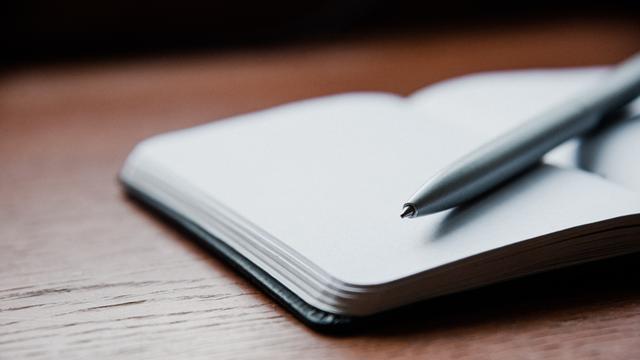 Ein Kugelschreiber liegt auf einem geöffneten Notizbuch