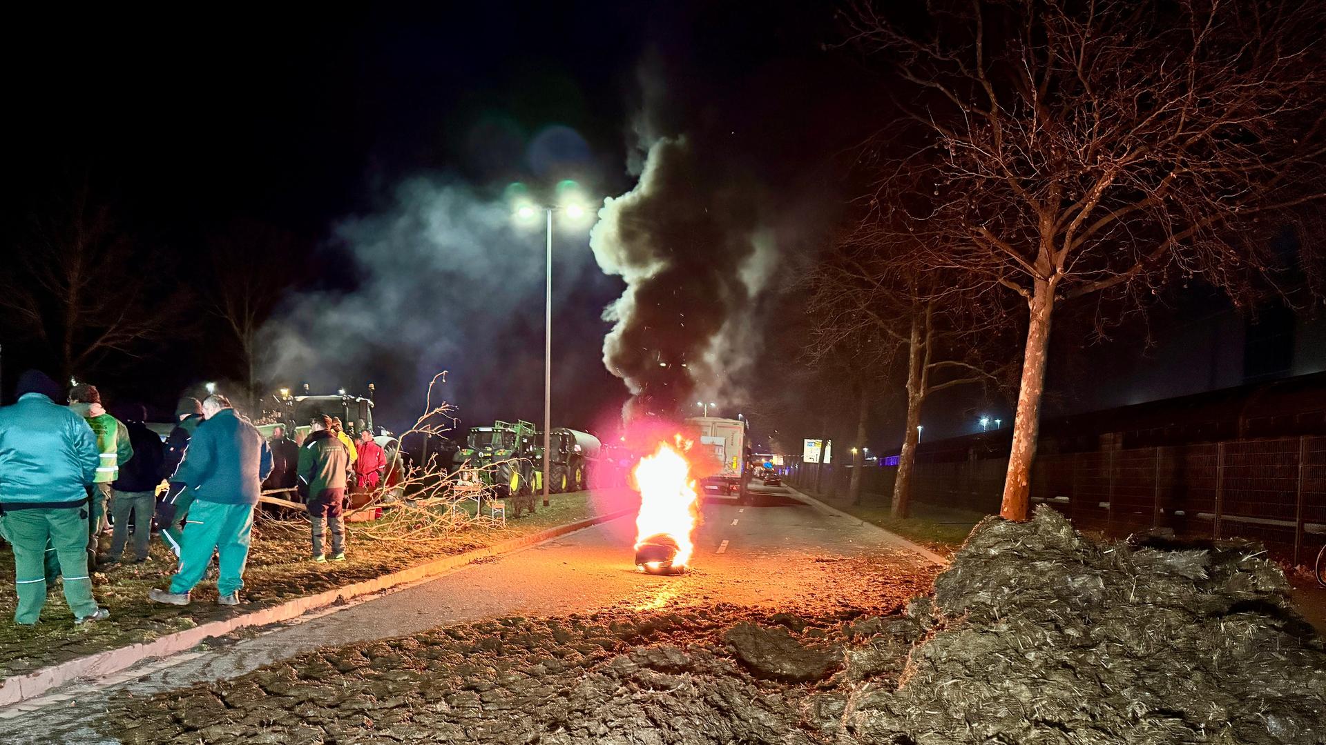 Magdeburg: Landwirte blockieren mit Mist und brennenden Reifen eine Straße bei Magdeburg.
