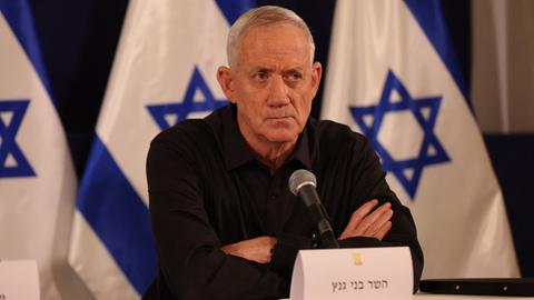 Benny Gantz, Mitglied im dreiköpfigen Kriegskabinett von Israels Ministerpräsident Benjamin Netanjahu. Er sitzt vor israelischen Flaggen.