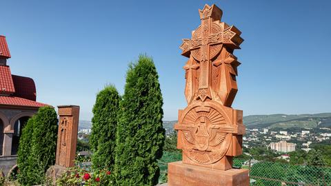 Steinkreuz aus Khachkar neben einer Kirche