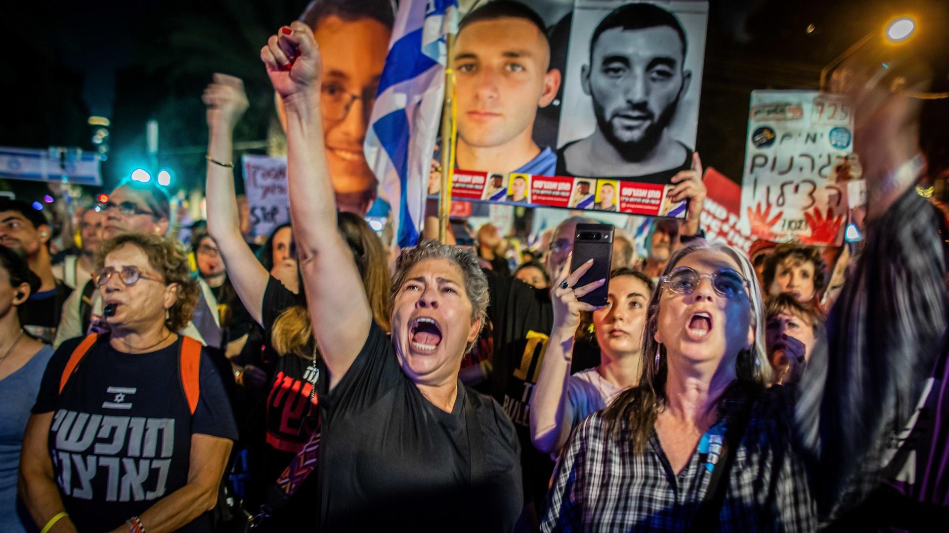 Israelische Demonstranten gestikulieren, skandieren und halten ein Plakat mit der israelischen Geisel Matan Angrest während einer Demonstration hoch. 