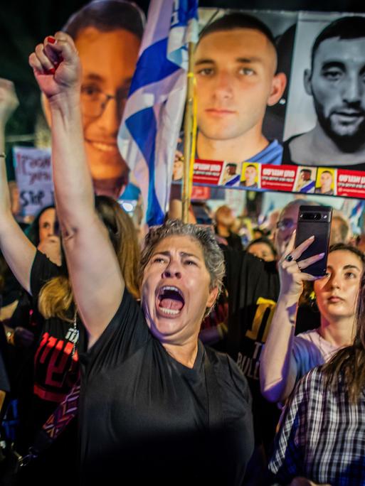 Israelische Demonstranten gestikulieren, skandieren und halten ein Plakat mit der israelischen Geisel Matan Angrest während einer Demonstration hoch. 