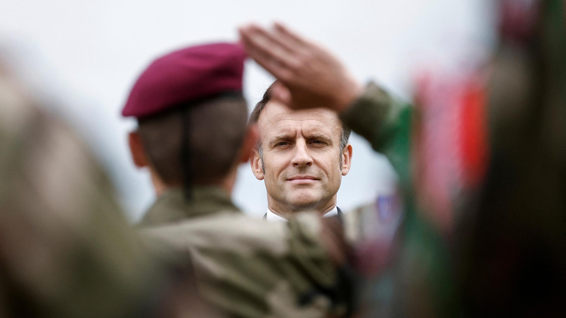 Frankreich, Plumelec: Ein Soldat salutiert vor Emmanuel Macron, Präsident von Frankreich, als dieser an einer Zeremonie zu Ehren der Saint Marcel Maquis, einer Gruppe französischer Widerstandskämpfer im Zweiten Weltkrieg, und der französischen Fallschirmjäger des SAS (Special Air Service), am Vorabend der Landung in der Normandie zum 80. Jahrestag des D-Day teilnimmt.