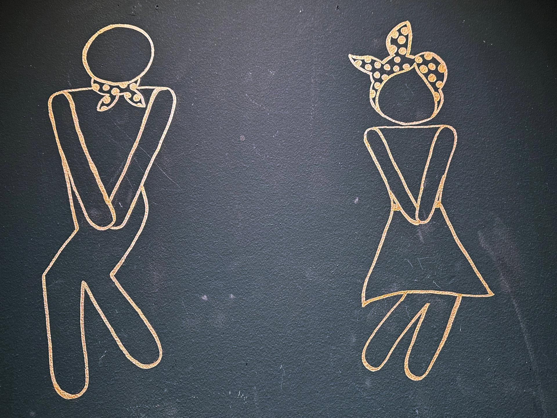 Stilisierte Zeichnungen von einem Mann und einer Frau an einer Toilette in Berlin.