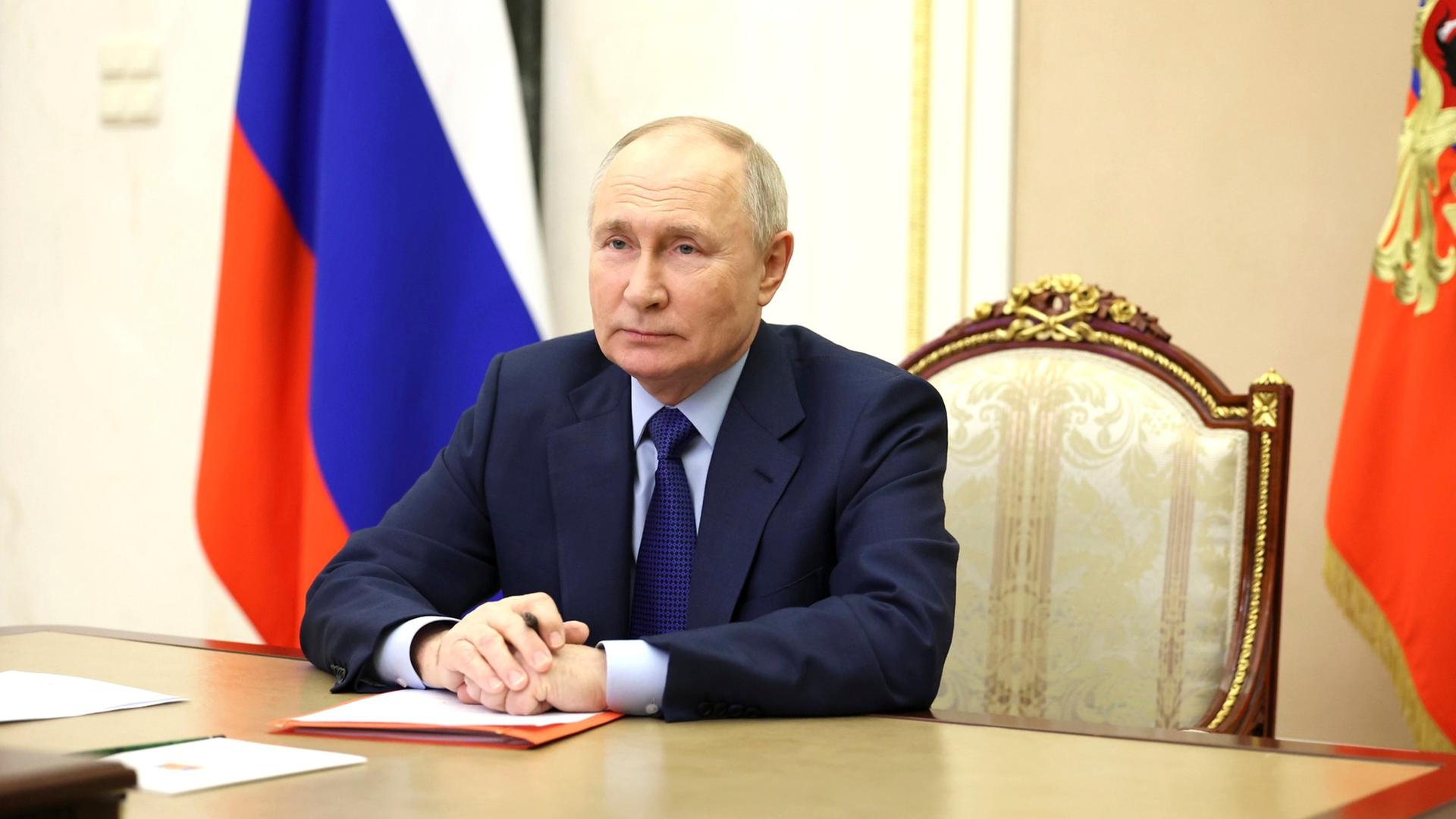 Russlands Präsident Putin sitzt an einem Schreibtisch.
