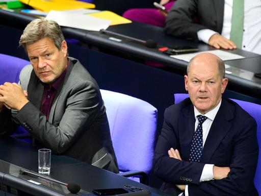 Robert Habeck (li.) und Bundeskanzler Olaf Scholz sitzen mit angespannten Gesichtern auf der Regierungsbank im Deutschen Bundestag. 