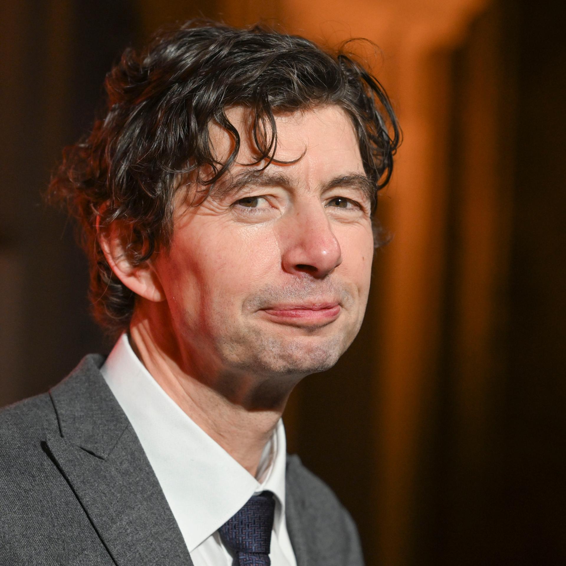 Der Virologe Christian Drosten blickt bei einem Empfang freundlich in die Kamera