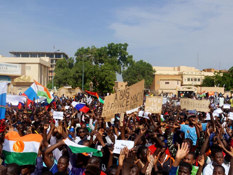Unterstützer des Putsches in Niger demonstrieren in der Hauptstadt Niamey mit Fahnen, Transparenten und Plakaten.