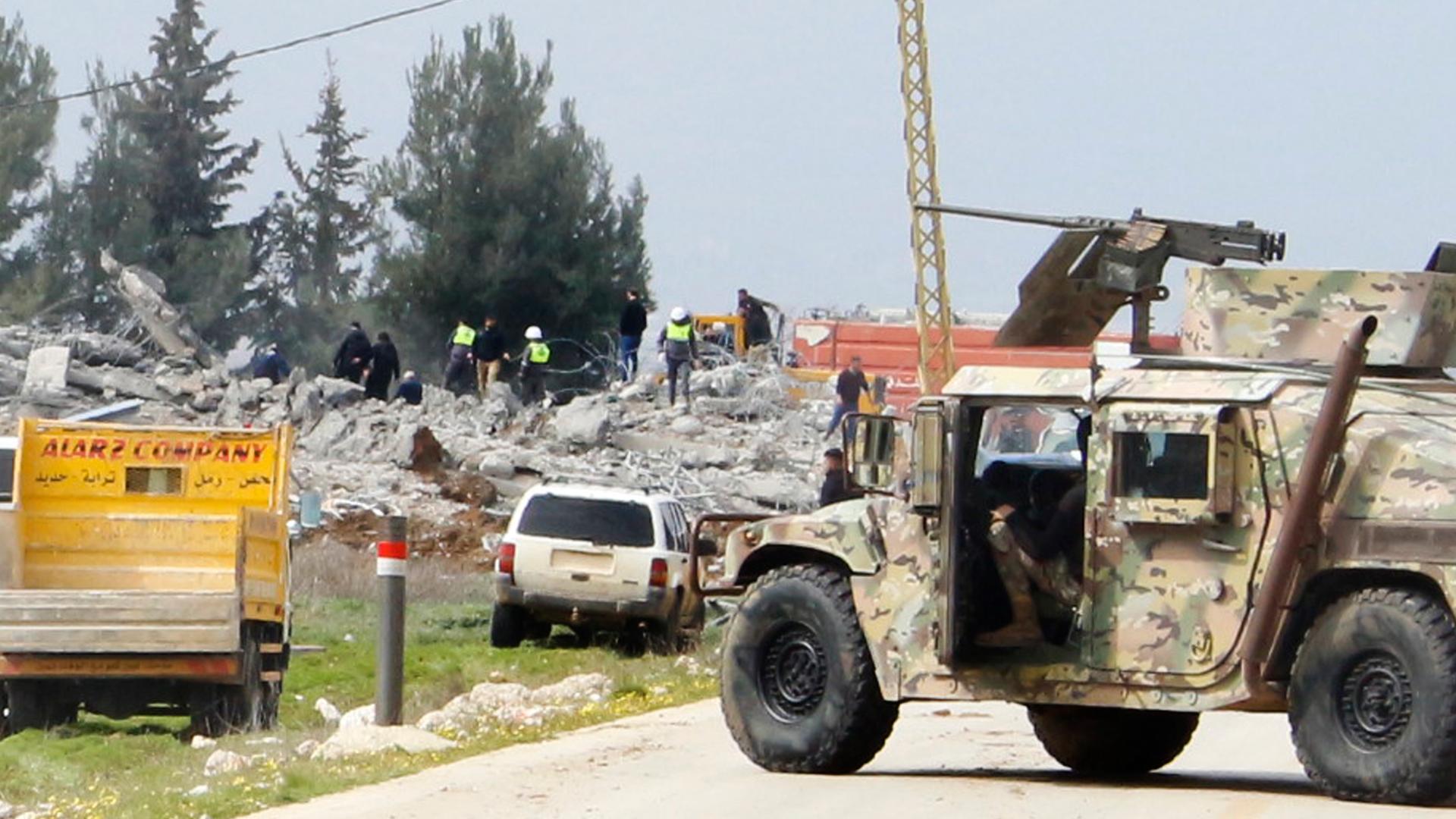 Ein Fahrzeug der libanesischen Armee blockiert eine Straße, die zu einem zerstörten Lagerhaus führt, das von israelischen Luftangriffen getroffen wurde. 
