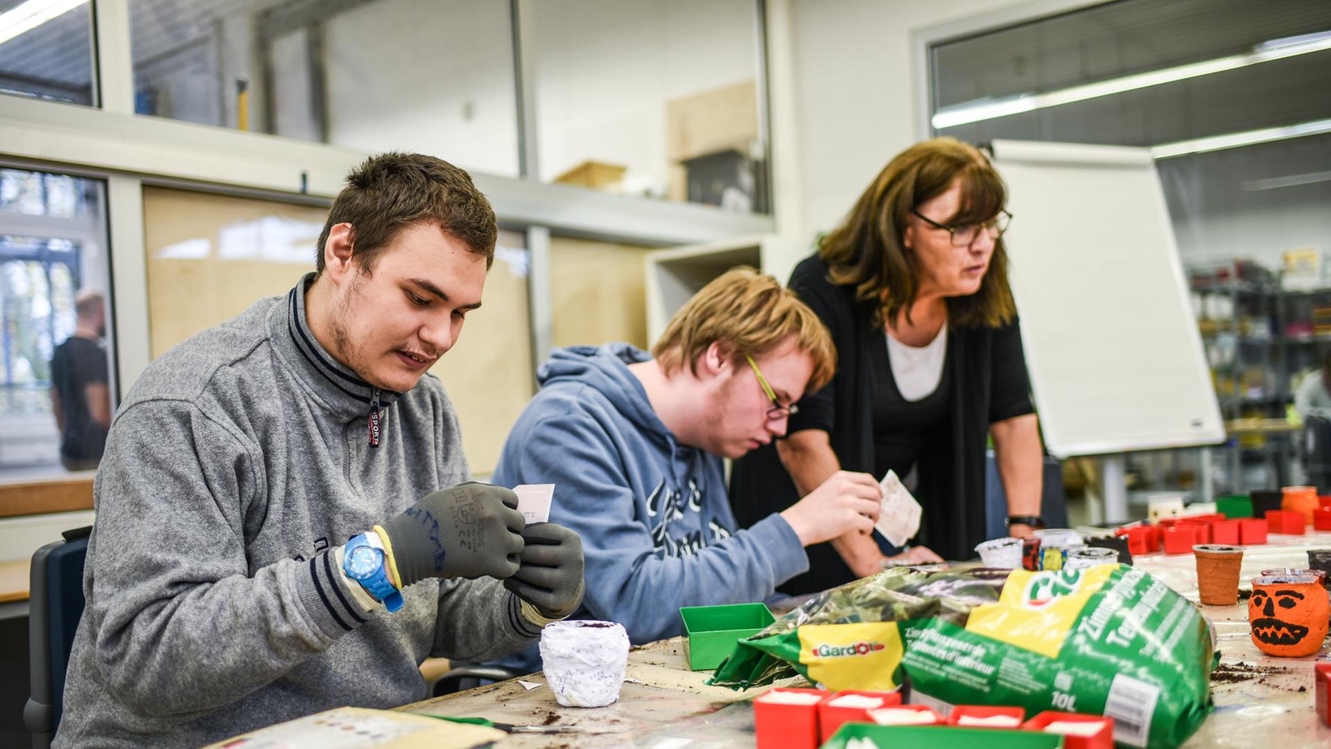 Menschen mit Behinderung arbeiten in einer Werkstatt. 