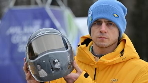 Der ukrainische Sportler Wladyslaw Heraskewytschmit seinem Helm, der gefallene ukrainische Sportler abbildet. 