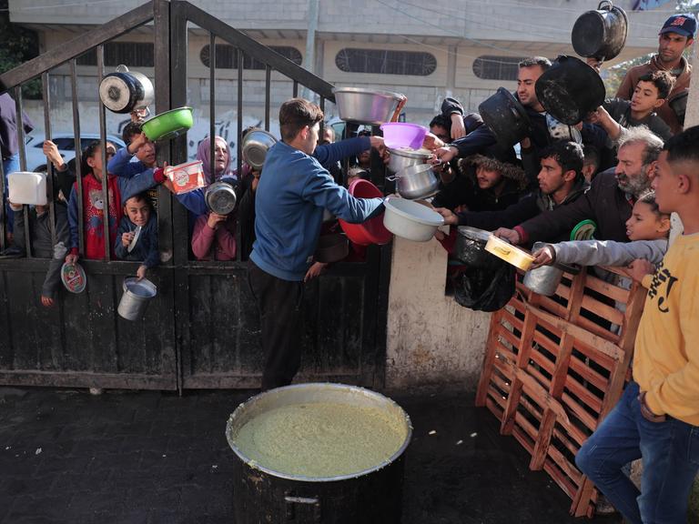 Palestinians gather with pots to receive food at a donation point provided by a charitable organization in Rafah Palestinians gather with pots to receive food at a donation point provided by a charitable organization in Rafah in the southern Gaza Strip, on December 19, 2023.