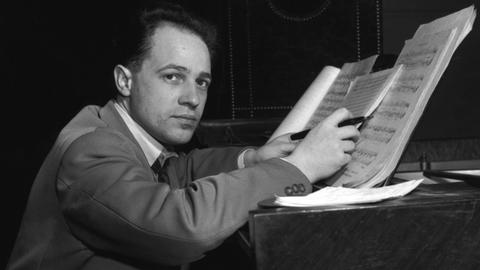 Pierre Boulez sitzt an einem Flügel und arbeitet an einem Werk. Foto um 1953.