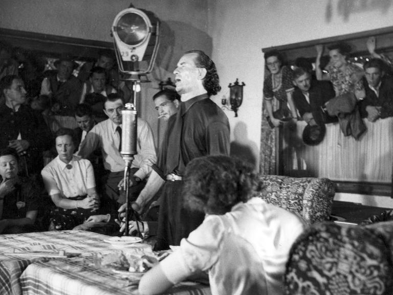 Eine historische schwarzweiss Aufnahme des "Wunderheilers" Bruno Gröning umringt von Anhängern, ca.1958.