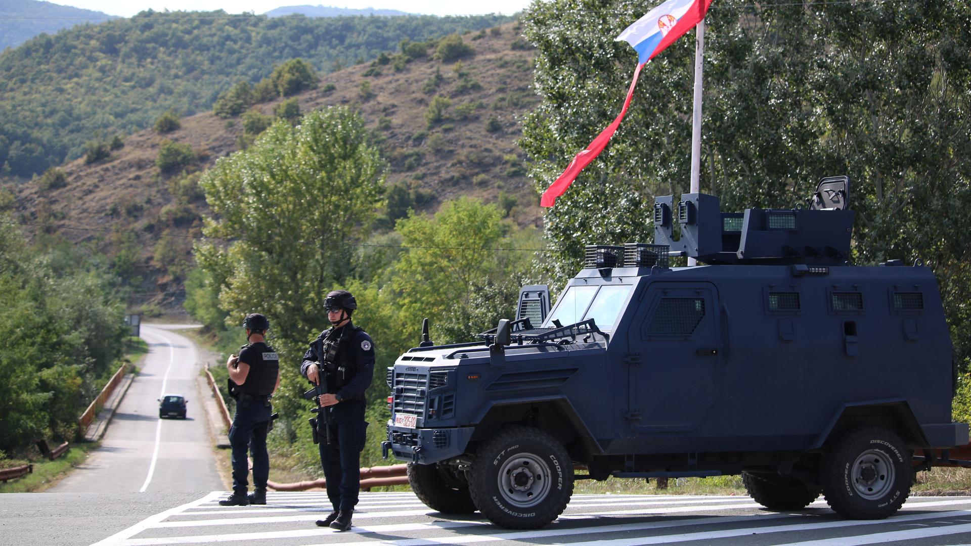 Kosovarische Polizisten und KFOR-Soldaten sichern eine Straße im Kosovo nachdem die Spannung mit Serbien zuletzt wieder aufgeflammt waren. 