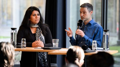 Saba-Nur Cheema und Meron Mendel sitzen bei einer Pressekonferenz nebeneinander an einem Podium.