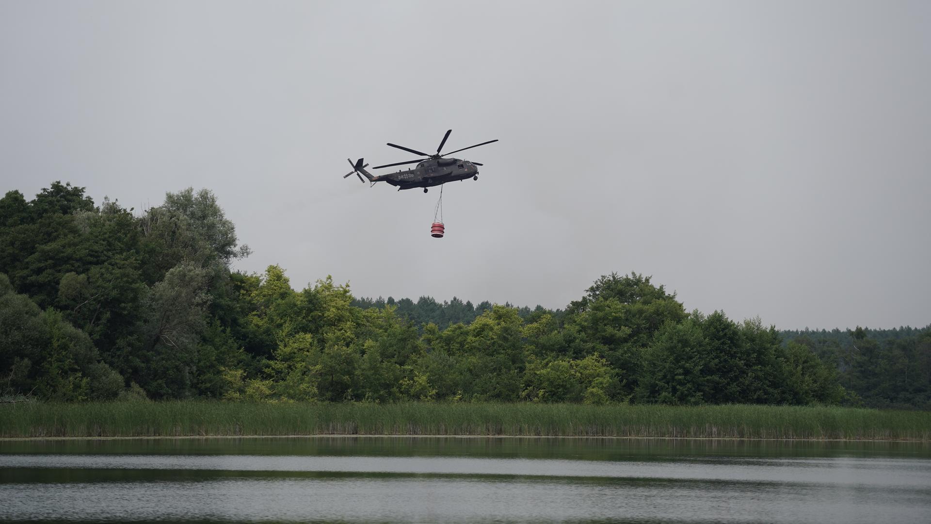 Ein mit Wassertanks ausgestatteter Transporthubschrauber der Bundeswehr unterstützt die Brandbekämpfung beim Waldbrand im Müritz-Nationalpark. Ein mit Wassertanks ausgestatteter Transporthubschrauber der Bundeswehr unterstützt die Brandbekämpfung beim Waldbrand im Müritz-Nationalpark.